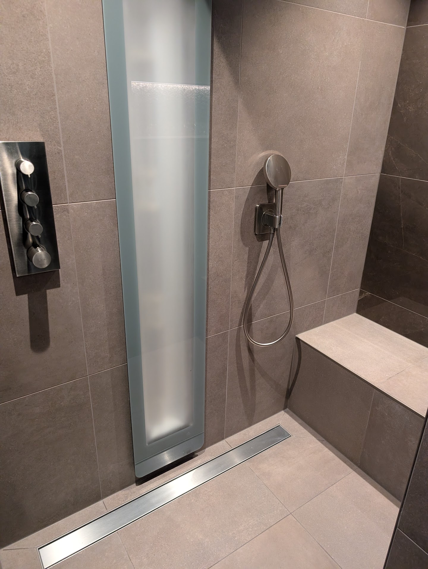 Strakke badkamer met keramische tegels en sunshower na reiniging